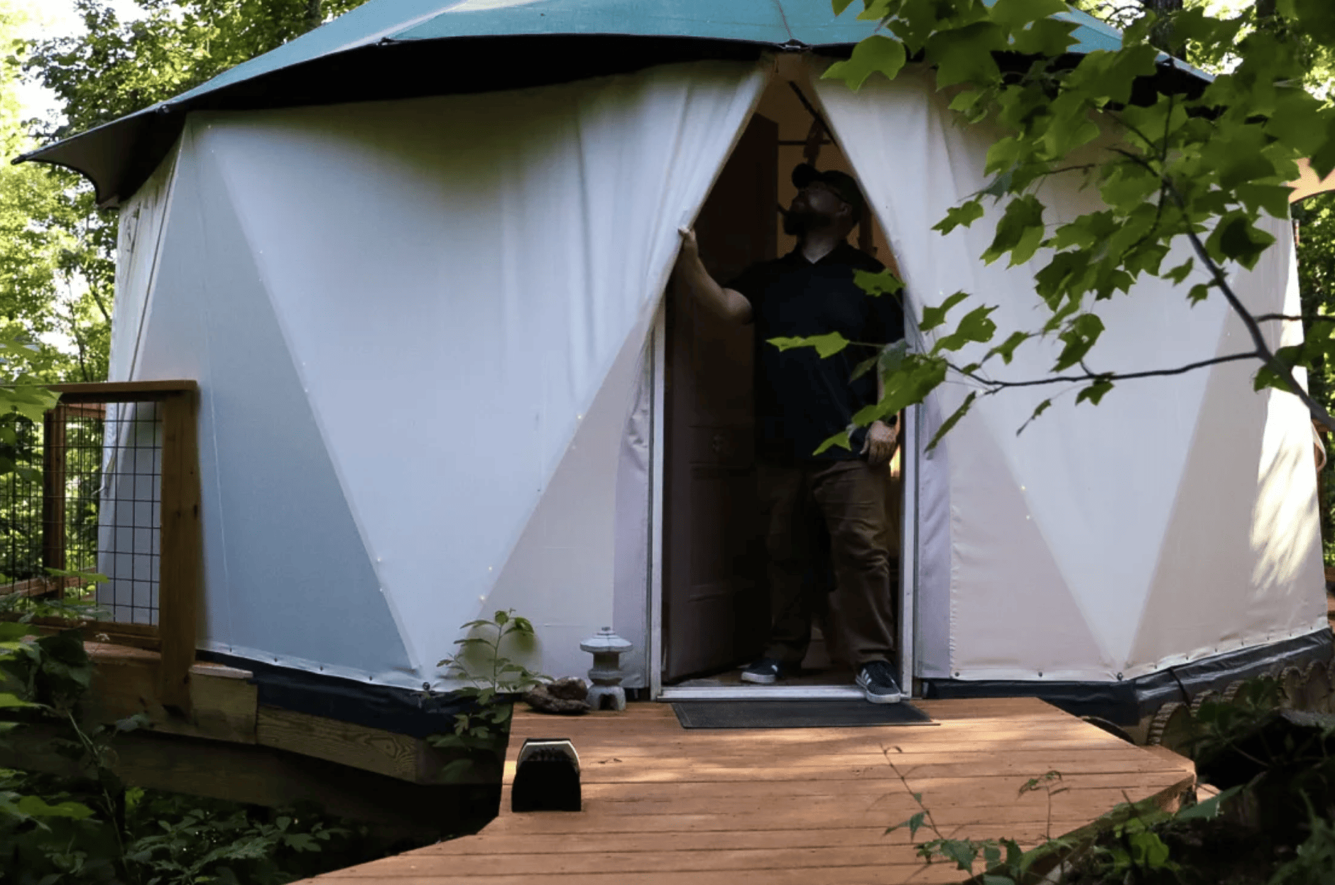 A man stands in the doorway of a yurt