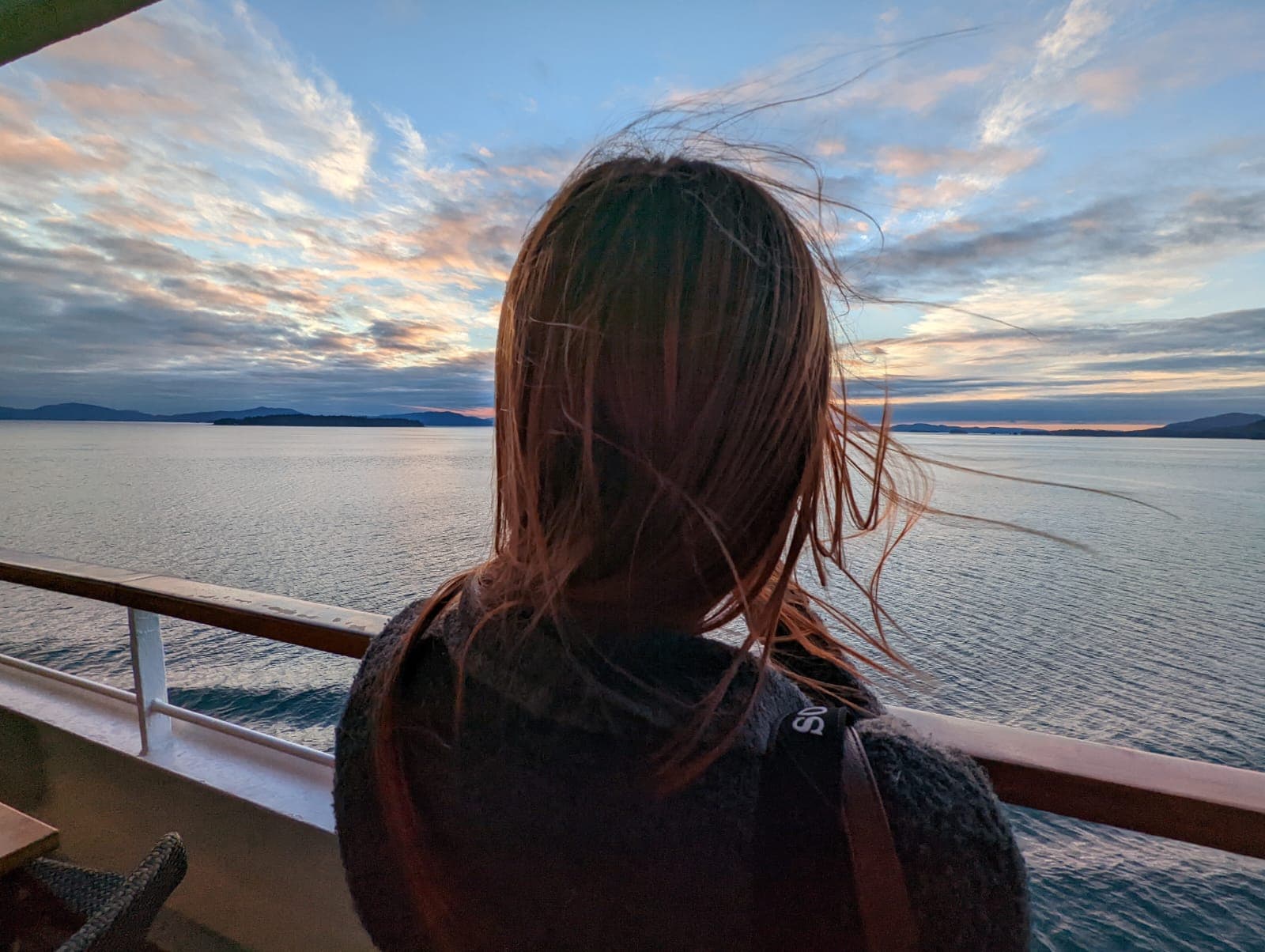 A girl looks out at the ocean from her cruise ship room