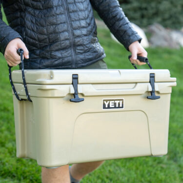 Carrying a YETI cooler in the grass